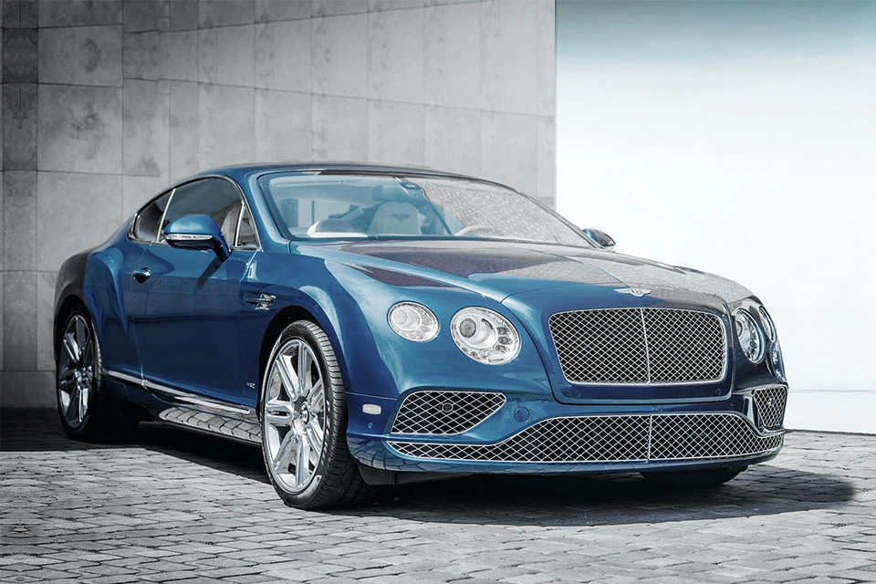 Blue Bentley on a cobbled road